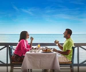 Couple enjoying a meal with ocean views at a seaside restaurant