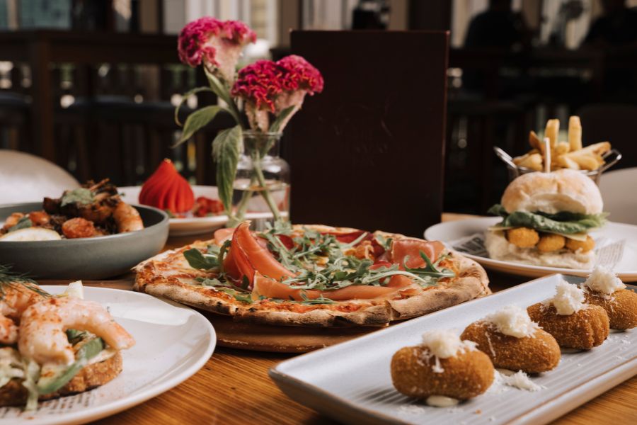 Selection of dishes including pizza, croquettes, burger, and seafood at Ternary Restaurant.
