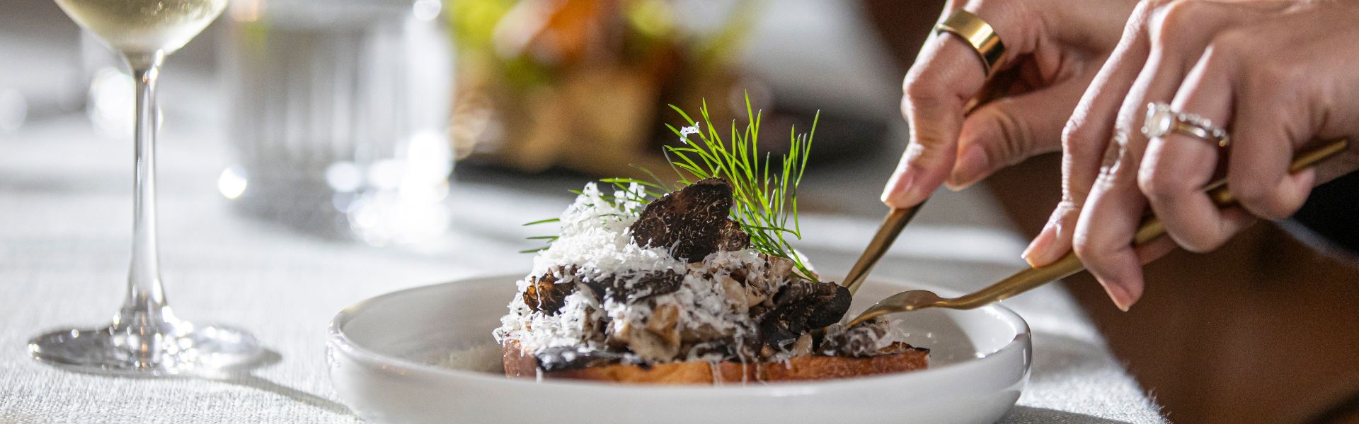 Diner enjoying a truffle mushroom dish from the Taste of The Ternary menu, served with white wine.